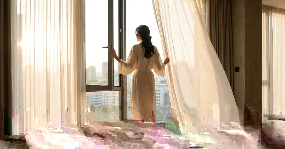 Open window with light coming through the curtains