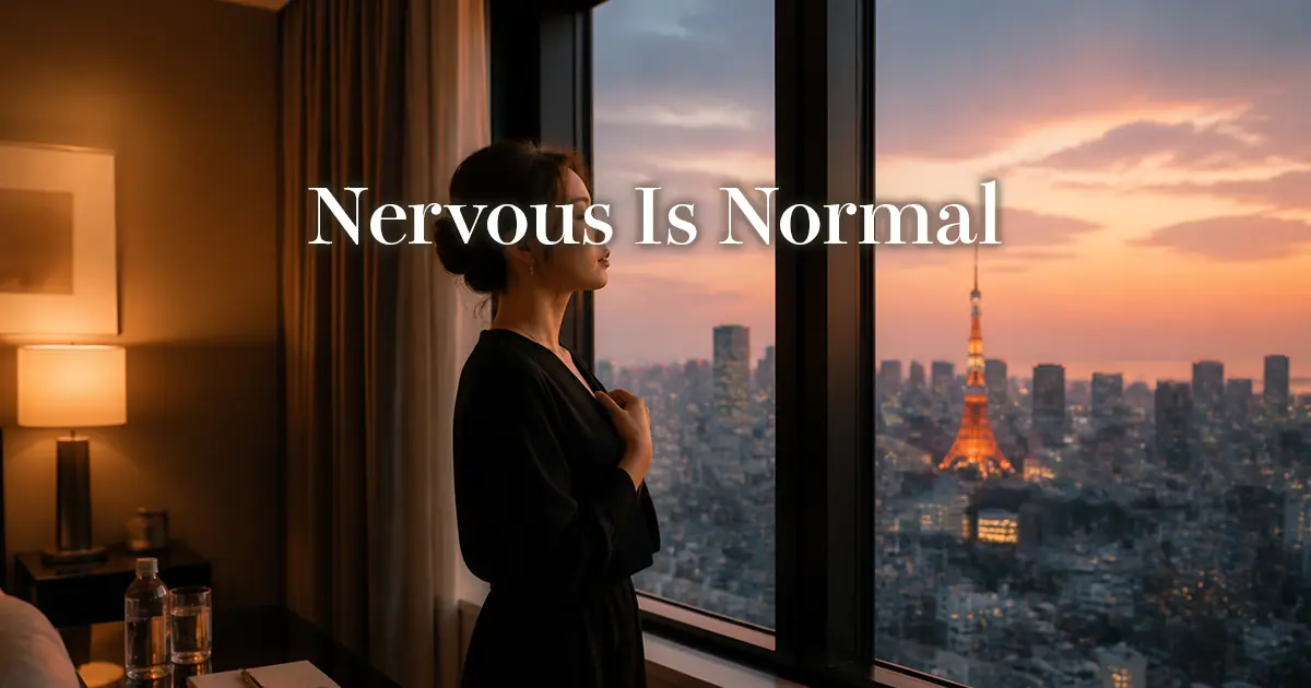 Woman pausing by a Tokyo hotel window at dusk, taking a calming breath before her first session