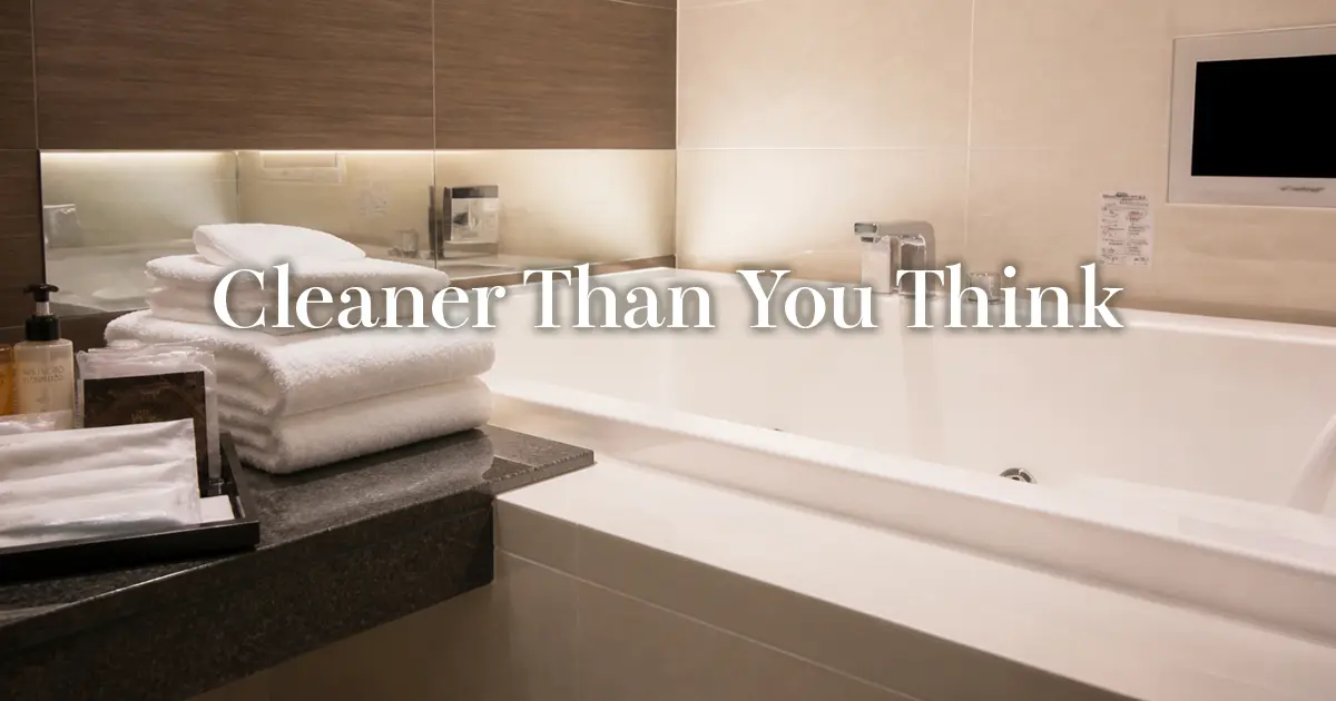 Folded white towels and amenities beside a large bathtub in a clean love hotel bathroom