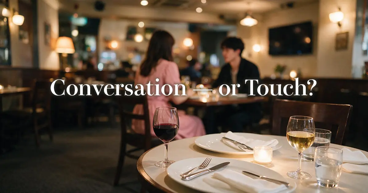 Dinner table for two at a Tokyo restaurant with wine glasses in warm light